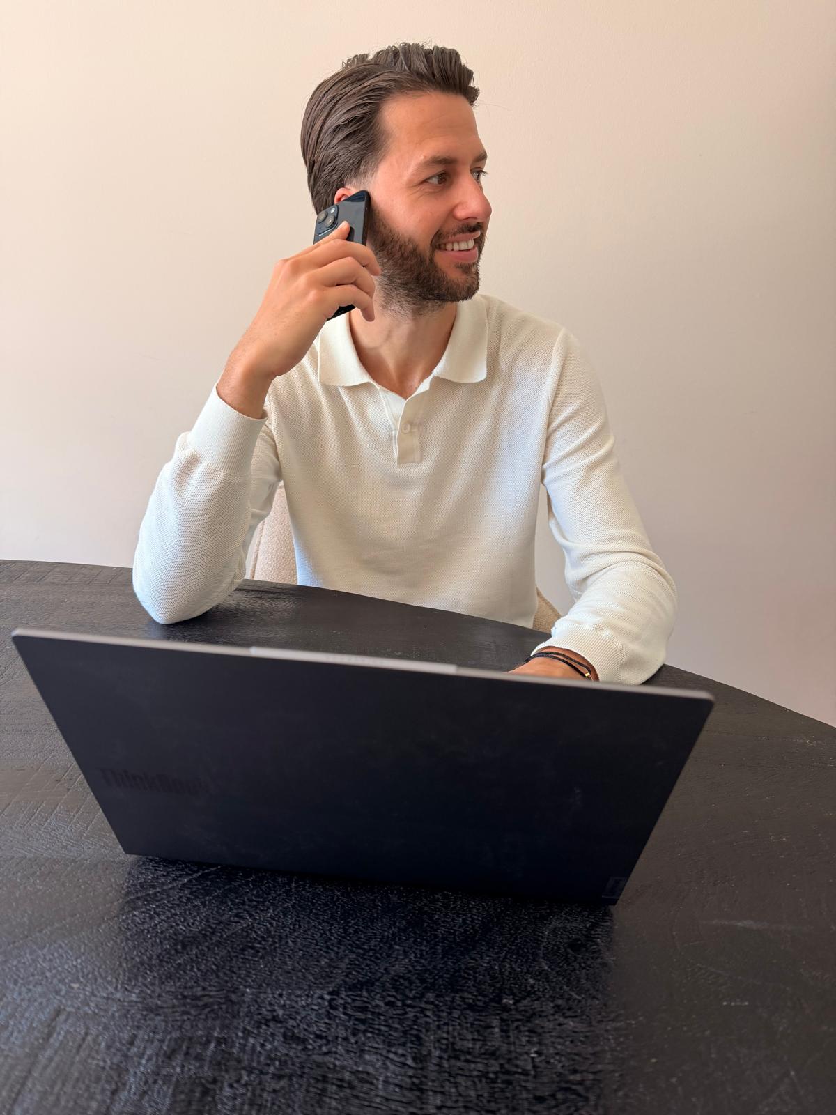 Bob Brooijmans aan de telefoon achter zijn laptop